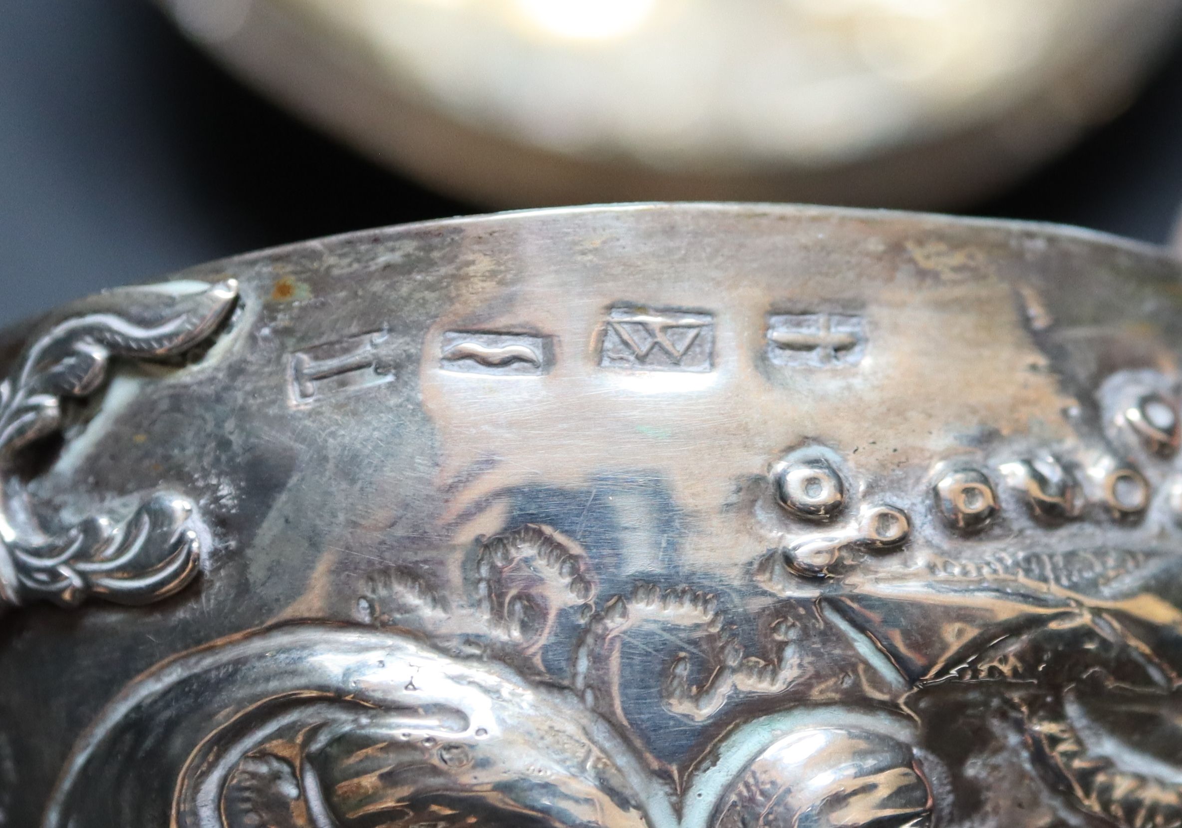 A 19th century Continental circular embossed white metal two handled pot and cover, 83mm, 99 grams. (a.f.)